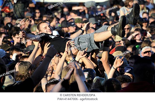 People in the audience enjoy crowd-surfing during a concert of the Wacken Open Air Festival 2013 in Wacken, Germany, 31 July 2013