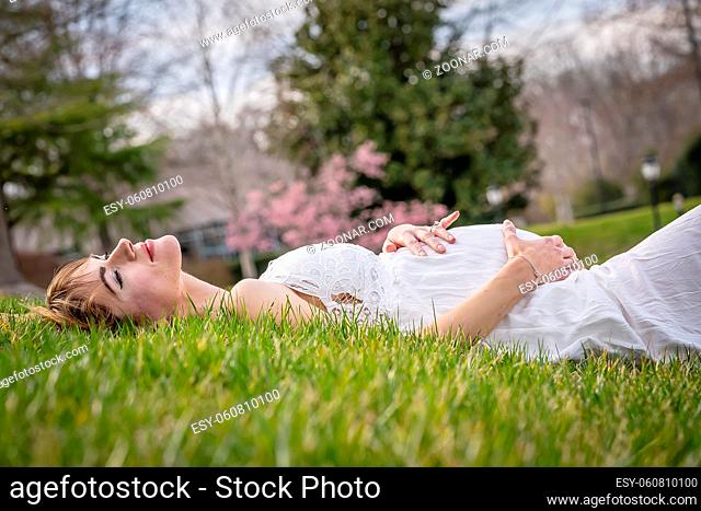 A beautiful expectant mother poses in an outdoor environment