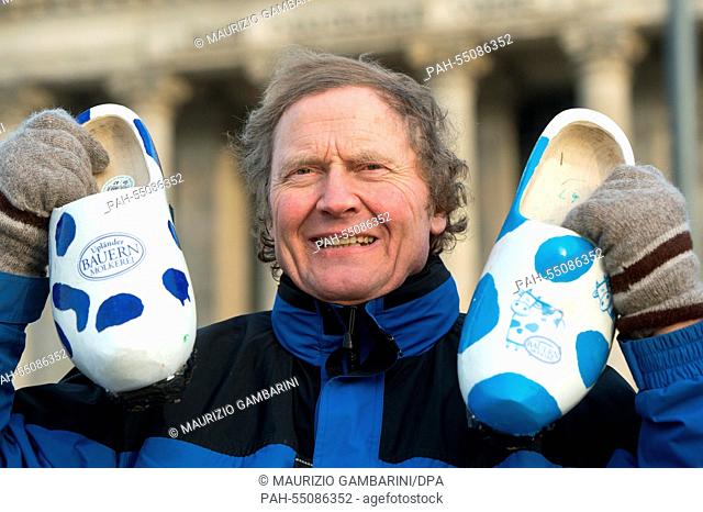 Organic farmer Otto Schoeneweis holds up his wooden shoes in front of the Reichstag in Berlin, Germany, 17 January 2015. He is protesting in wooden shoes...