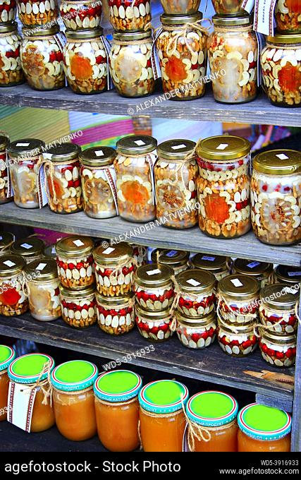 Canned of tasty ceps haricots nuts and mushrooms on counter. Delicious homemade canned mushrooms haricots and nuts. Preserved food