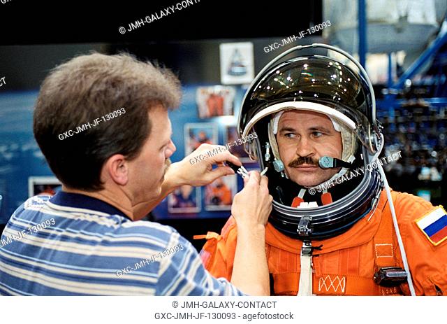 Cosmonaut Nikolai M. Budarin, Expedition Six flight engineer, assisted by United Space Alliance (USA) suit technician Brad Milling