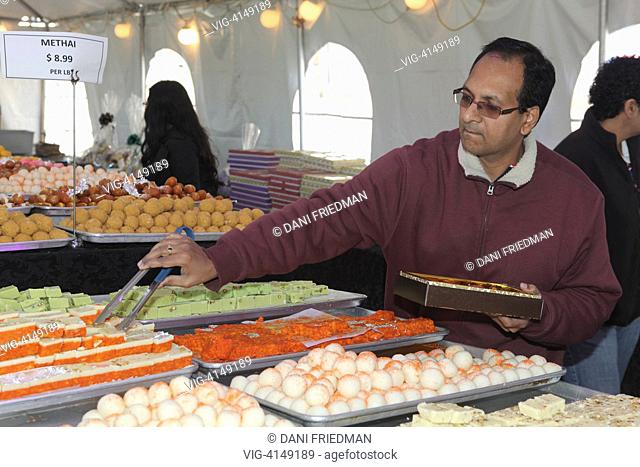 CANADA, MISSISSAUGA, 03.11.2013, Hindu-Punjabi man selecting traditional Indian sweets during the festival of Diwali at a sweetshop in Mississauga, Ontario