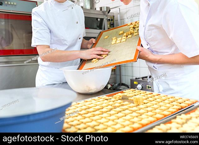 Cookies being baked in pastry bakery being slid off sheet