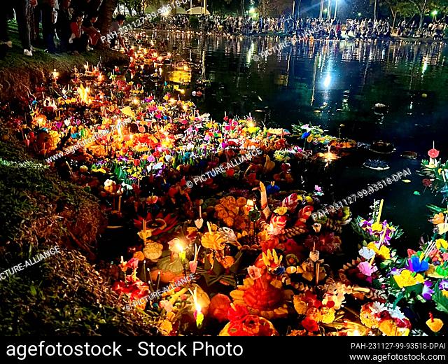 27 November 2023, Thailand, Bangkok: Krathongs float in a lake in Lumphini Park, one of Bangkok's largest parks. The small rafts are made of banana trees or...