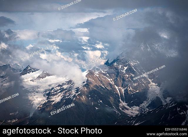 Cloud cliffs on the tops of the Caucasus mountains covered with snow