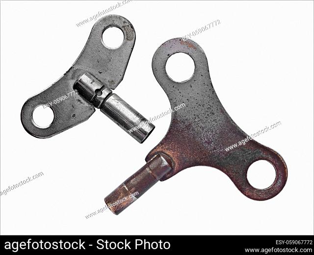 pair of vintage wind clock keys over white, clipping path