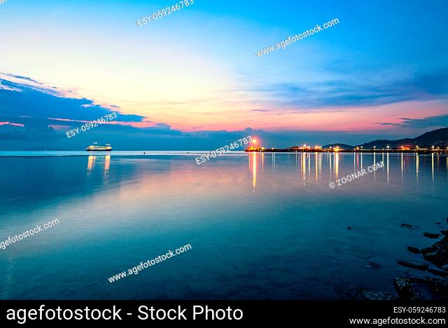 Beautiful natural landscape of the light reflecting the surface at Nathon Pier and boat on colorful sky twilight after sunset over the sea at Ko Samui island