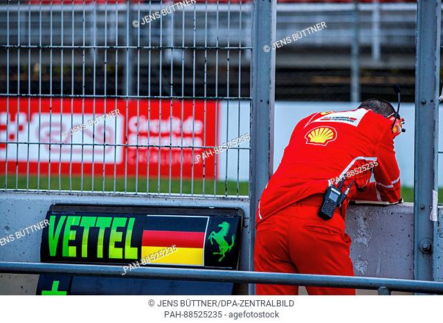 A mechanic from from Ferrari near a sign of the German team at the Formula One pre-season testing at the Circuit de Catalunya race track in Barcelona, Germany