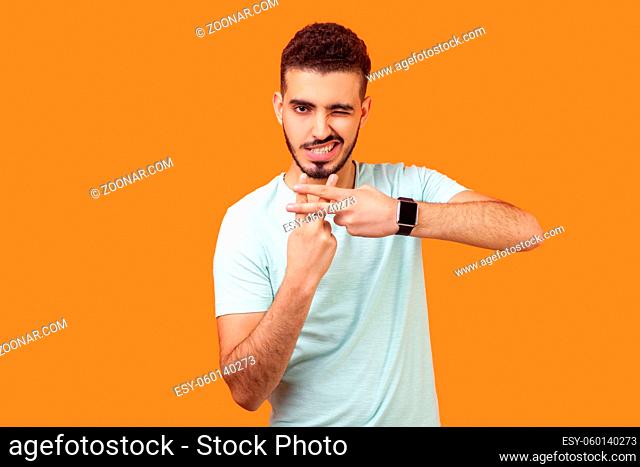 Hashtag. Portrait of joyous handsome brunette man with beard in casual white t-shirt making hash gesture and winking at camera, popular blog content