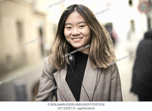 young smiling Asian woman in streets of Paris, France