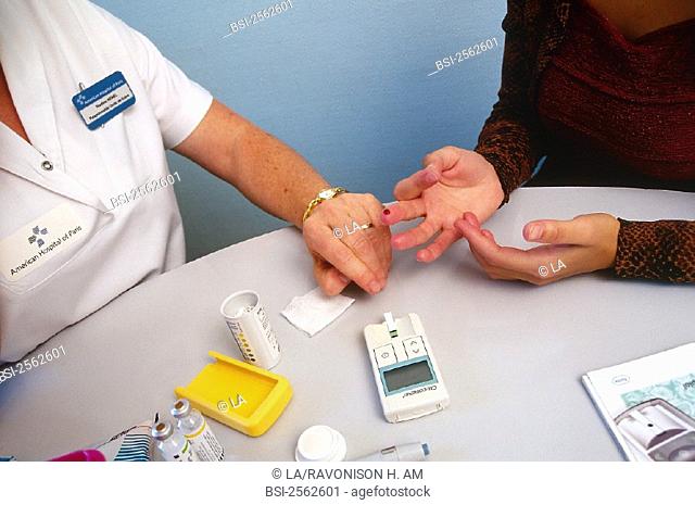 WOMAN CONSULTING FOR DIABETES<BR>Model and nurse.<BR>American Hospital of Paris, in the French region of Ile-de-France. Glycemia test