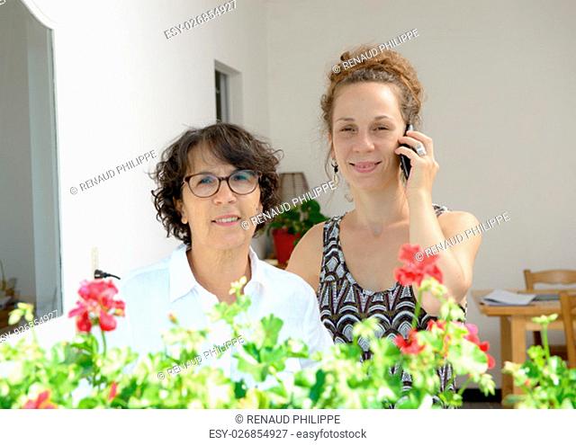a mother and daughter on the phone in home