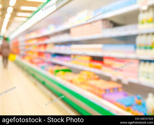 Defocused blur of supermarket shelves with dairy products. Blur background with bokeh. Defocused image