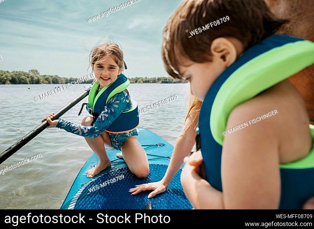 Girl paddleboarding on lake at weekend