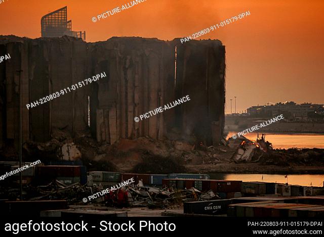 03 August 2022, Lebanon, Beirut: Fire and smoke are seen billow from the devastated Beirut port wheat silos during sunset