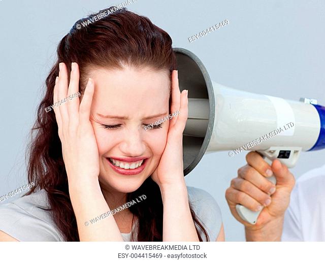 Angry businesswoman listening to a megaphone