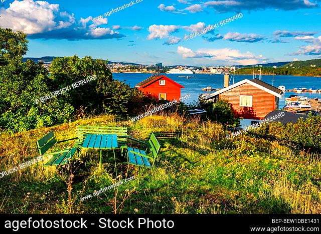 Oslo, Ostlandet / Norway - 2019/09/02: Panoramic view of Nakholmen island on Oslofjord harbor with summer cabin houses at shoreline in early autumn