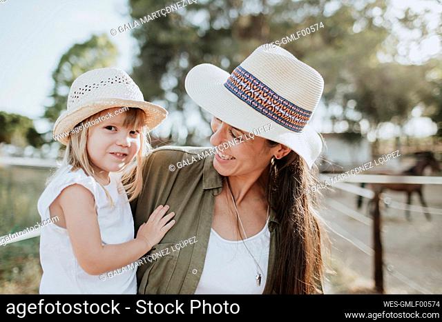 Close-up of mother carrying cute daughter while standing outdoors