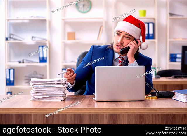 Young employee working in the office at Christmas Eve