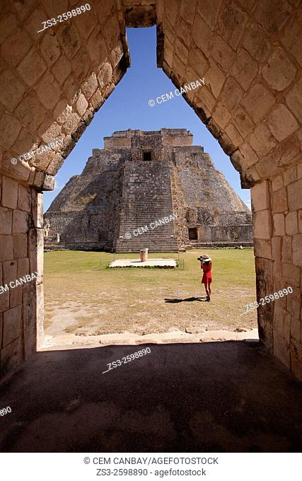 Tourist taking photos of the the Pyramid of the Magician, Maya archeological site Uxmal, Yucatan, Mexico, Central America