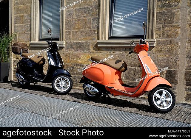 germany, bavaria, upper franconia, bamberg, two parked motor scooters, vespa, house wall