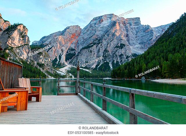 Old wooden house on the Braies lake in the background of Seekofel mountain in Dolomites, Italy ( Pragser Wildsee )