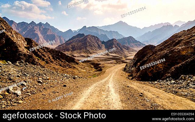 Hiking trail and dirt road through Hajar Mountains near Hatta, UAE