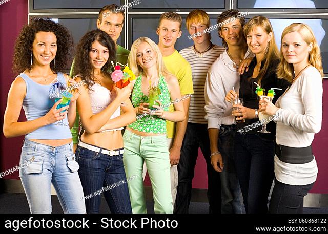 Large group of teenagers during the party. Looking at camera and smiling. Girls holding drinks