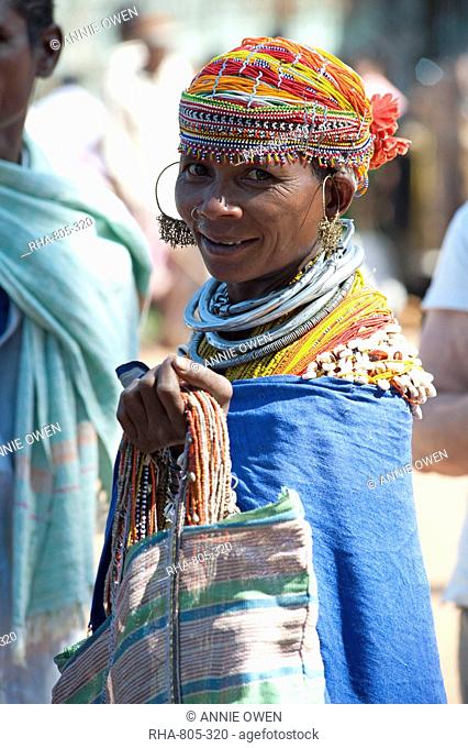 Smiling Bonda tribeswoman wearing cotton shawl over traditional bead costume, beaded cap, large earrings and metal necklaces, Rayagader, Orissa, India, Asia