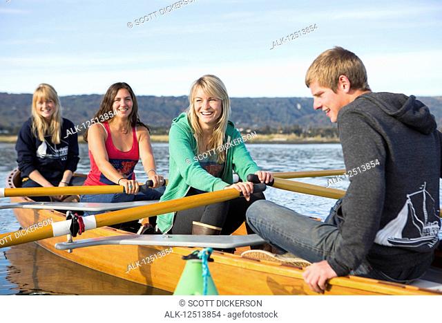 Young adults rowing in a canoe, South-central Alaska; Homer, Alaska, United States of America