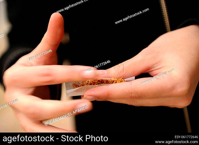 Young woman rolling a joint