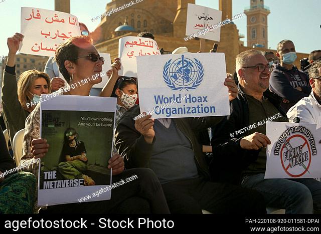 08 January 2022, Lebanon, Beirut: Demonstrators hold placards during a protest against mandatory Covid-19 vaccination. The numbers of coronavirus cases hiked up...