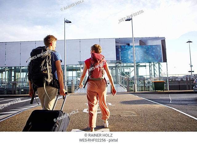 Rear view of couple walking outside airport