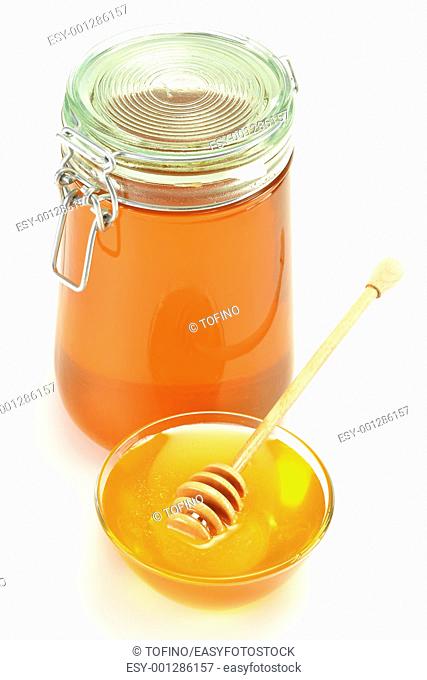 Composition with dish of honey and stick isolated on white