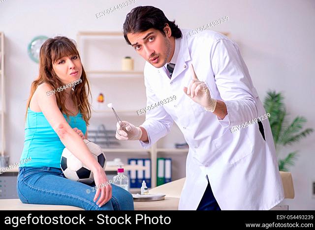 The young arm injured woman visiting young doctor traumatologist