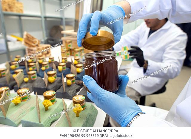 10 April 2019, North Rhine-Westphalia, Remscheid: A prisoner locks a glass of honey in the prison workshop. In NRW, prisoners become active in the fight against...