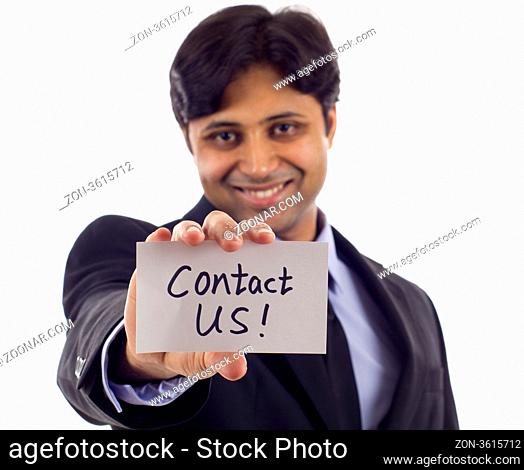 Smiling Asian business man holding a card- Contact Us! isolated over white background