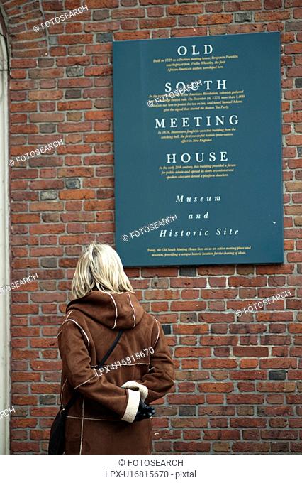 Woman looking at the Old South Meeting House sign in Boston, Massachusetts, USA