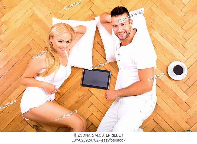 A beautiful young couple on the floor in their new home