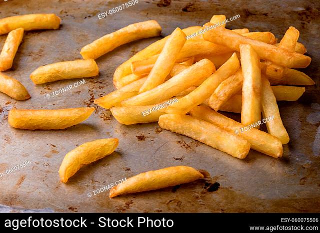 fresh yellow fries on grungy steel plate
