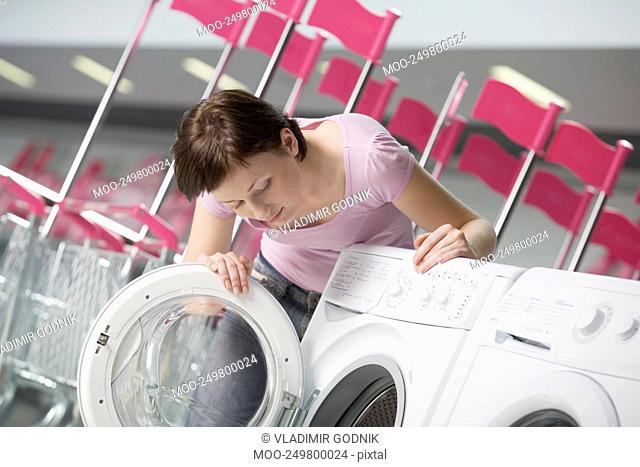 Young woman chooses washing machine in shopping mall Voronezh