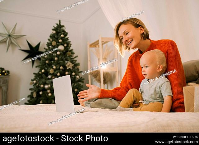 Mother and son on video call through laptop at home