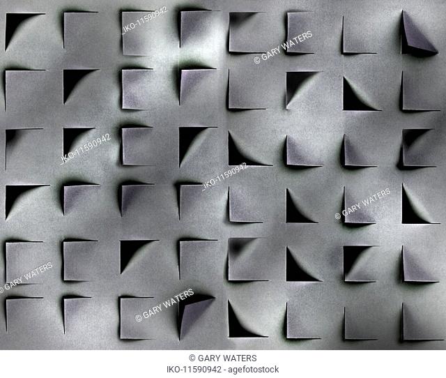 Abstract pattern of shadows and square holes in cut paper