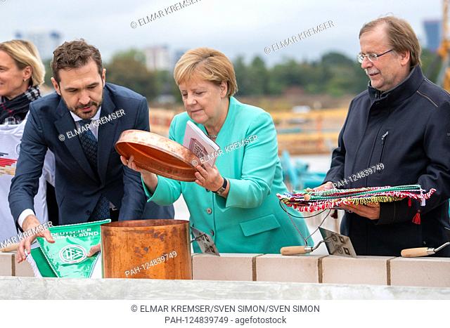 From left to right Friedrich CURTIUS (DFB Secretary General), dr. Angela MERKEL (Chancellor GER), dr. Rainer KOCH (1.DFB Vice President), fill the Zewitkapsel