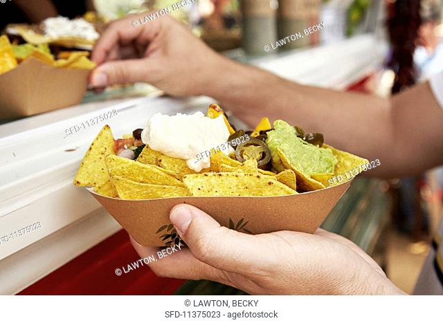 Tortilla chips with sour cream and guacamole at a market (Barcelona, Spain)