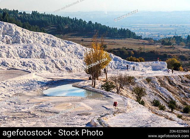 PAMUKKALE, TURKEY - NOVEMBER 16, 2015: People walking on travertine pools and terraces in Pamukkale. Pamukkale is a famous historical place with travertine...