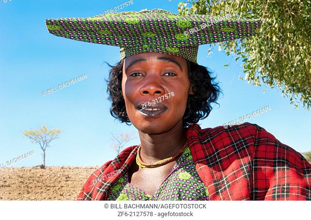 Namibia Africa Northern Desert colorful Herero tribe woman in plaid dress and hat and traditional costume in Tomakas in Puros Conservancy remote village