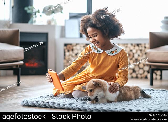 Selfie with puppy. A pretty smiling girl with a puppy making selfie on her device