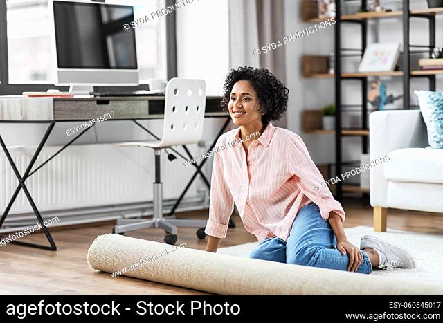 smiling young woman sitting on carpet at home
