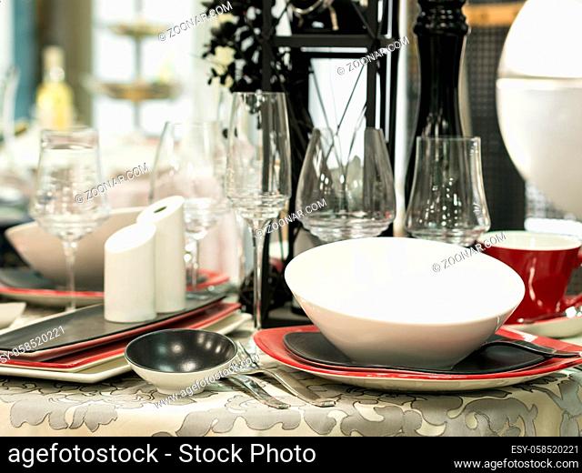 Set of new dishes on table with tablecloth. Shallow DOF